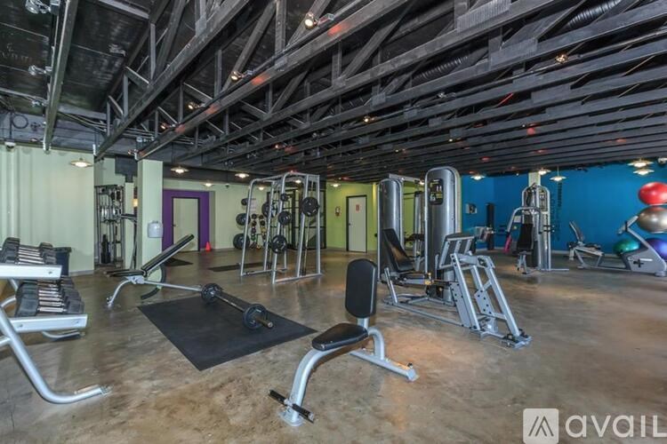 A gym with a variety of equipment including weights and cardio machines.