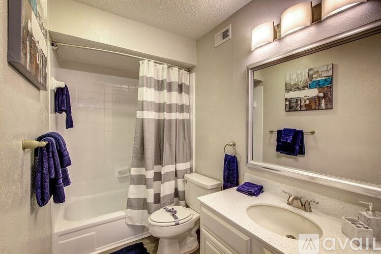 A bathroom with a toilet, sink, and shower.