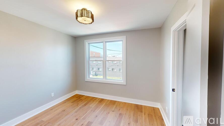 A room with a window and wooden flooring.