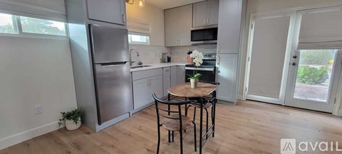 A kitchen with a table and chairs in the middle of the room.