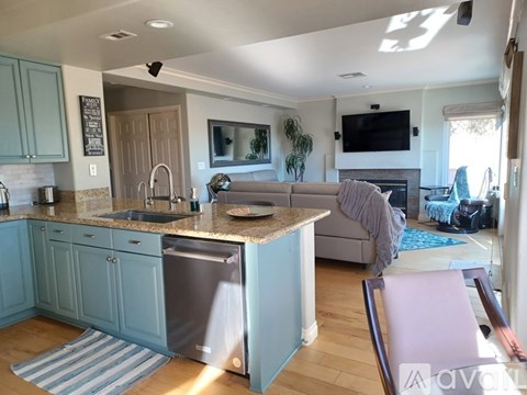 A kitchen with a sink and a couch.