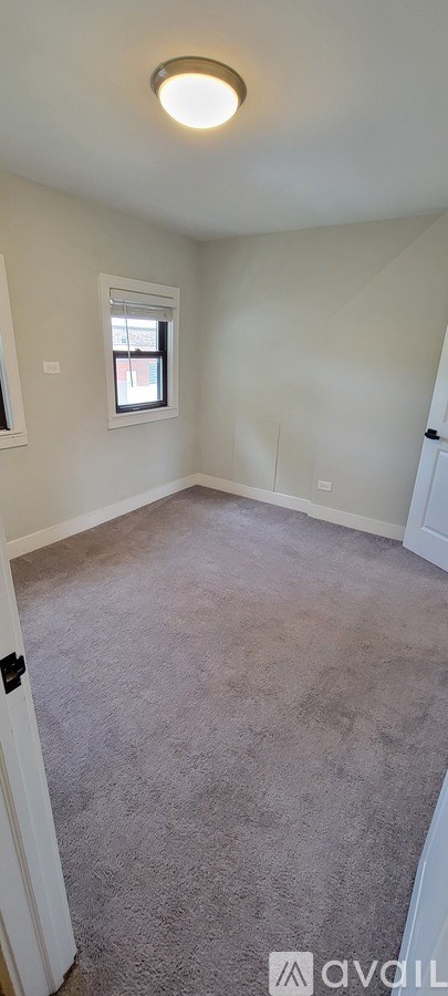 A room with a carpeted floor and a window.