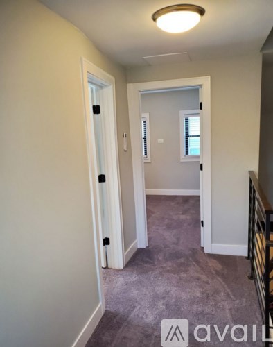 A hallway with two doors and a carpeted floor.