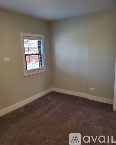 A room with a window and a carpeted floor.