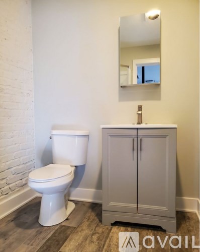 A white toilet sits next to a cabinet in a bathroom.