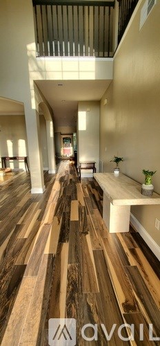 A hallway with wooden floors and a bench.