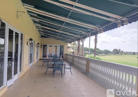 A patio with a table and chairs overlooking a golf course.