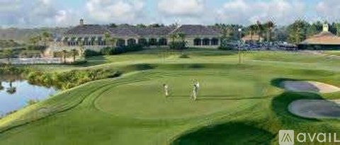 A golfer is on a golf course with a water hazard to the left.