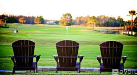 Three chairs are lined up on a lawn.