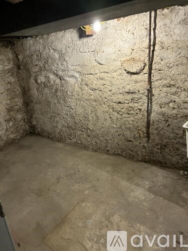 A room with a stone wall and a concrete floor.