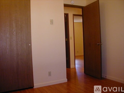 A room with a brown door and a white wall.