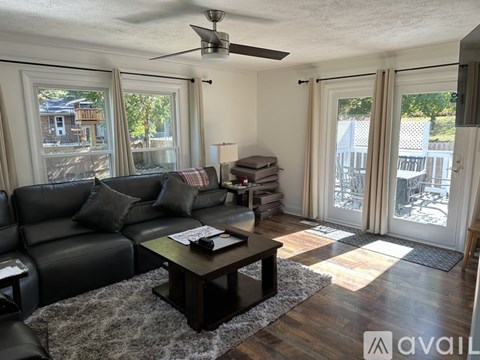 A living room with a black leather couch and a wooden coffee table.