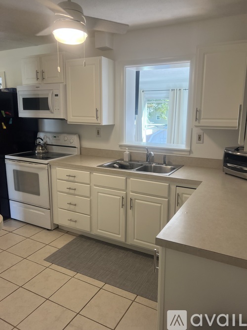 A kitchen with white cabinets and appliances.