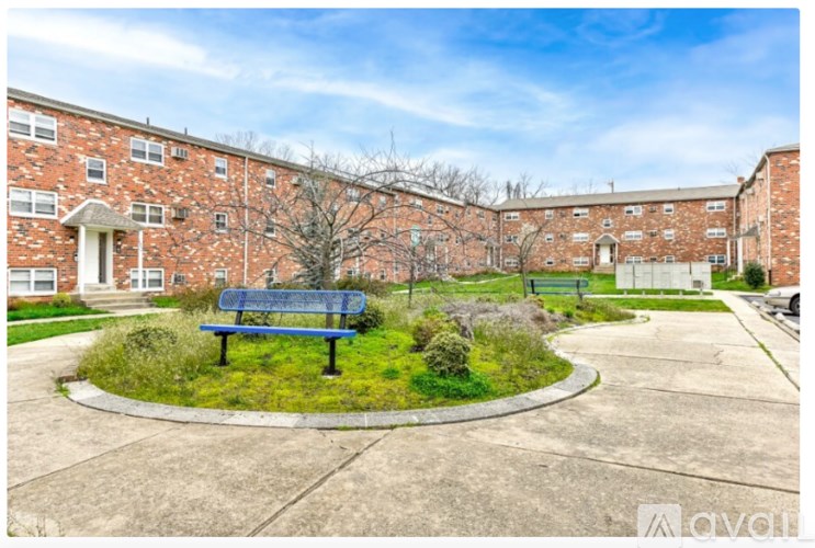 A brick building with a blue bench in front of it.