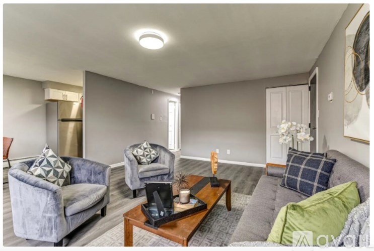 A living room with a grey couch, a blue chair, and a wooden coffee table.