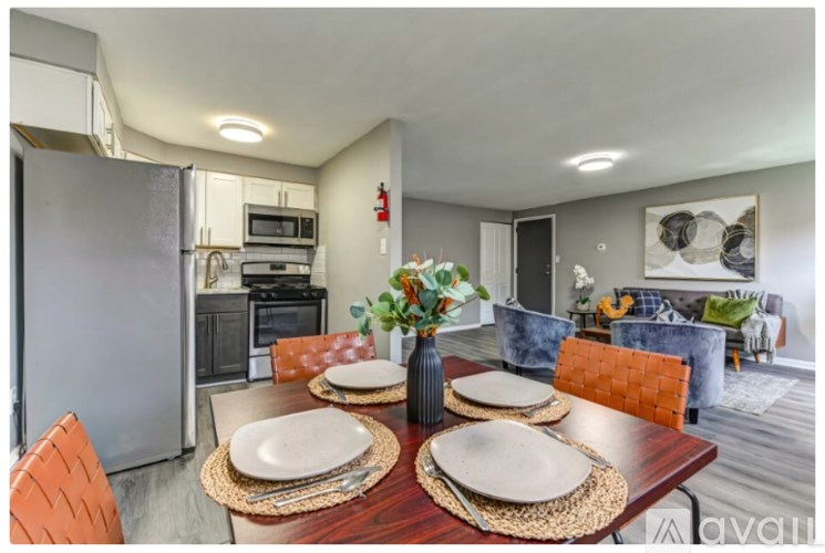 A kitchen with a table set for two and a refrigerator.