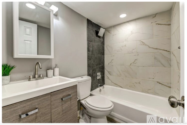 A bathroom with a white sink, toilet, and bathtub.