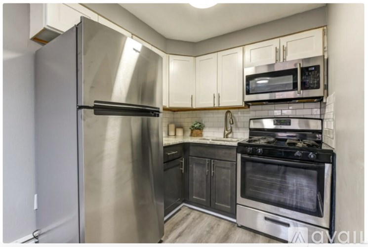 A kitchen with a stainless steel refrigerator, microwave, and oven.