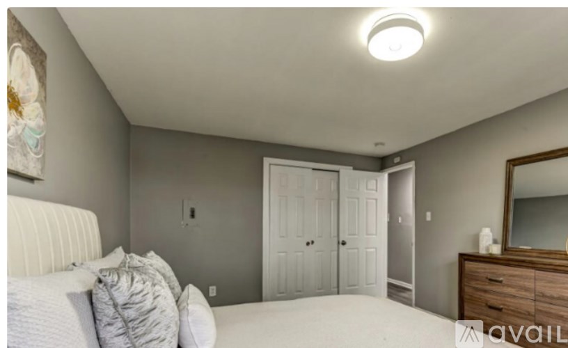 A bedroom with a bed, dresser, and mirror.