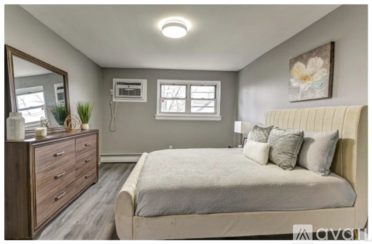 A bedroom with a bed, dresser, and mirror.