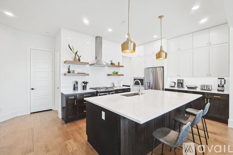 A kitchen with a white countertop and black cabinets.