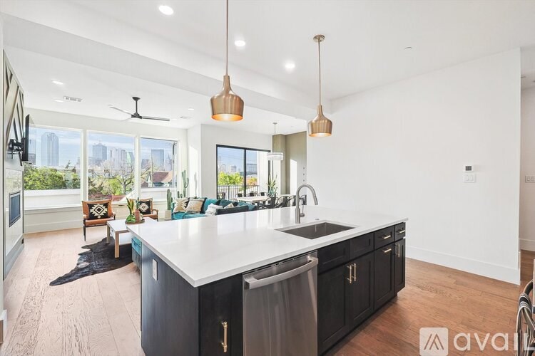 A modern kitchen with a large island and pendant lights.