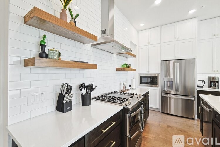 A kitchen with white countertops and a stainless steel refrigerator.