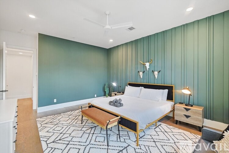 A bedroom with a bed, nightstand, and chair.