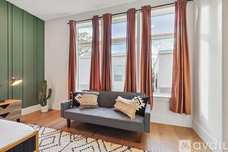 A living room with a grey couch and brown curtains.
