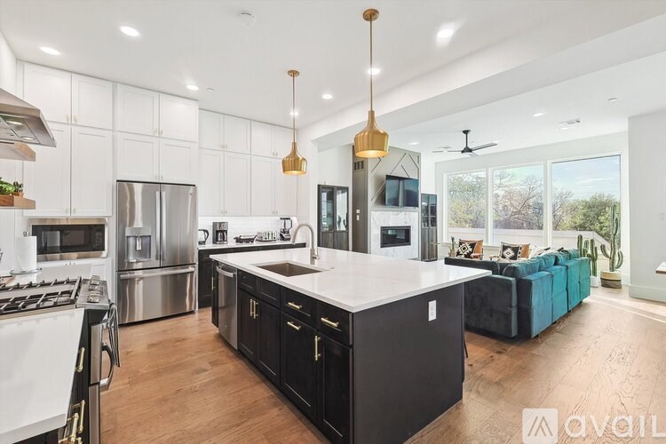 A modern kitchen with a large island and stainless steel appliances.