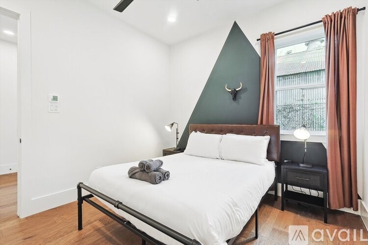 A bedroom with a bed, nightstand, and a deer head on the wall.