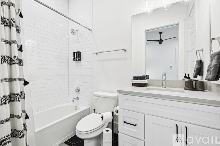 A white bathroom with a toilet, sink, and shower.