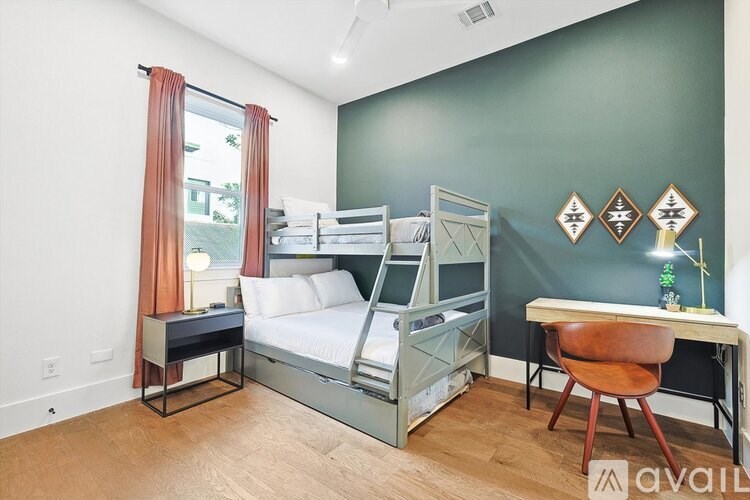 A bedroom with a bunk bed and a desk.