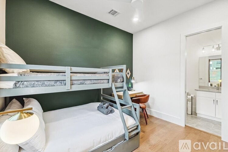 A bedroom with a bunk bed and a desk.