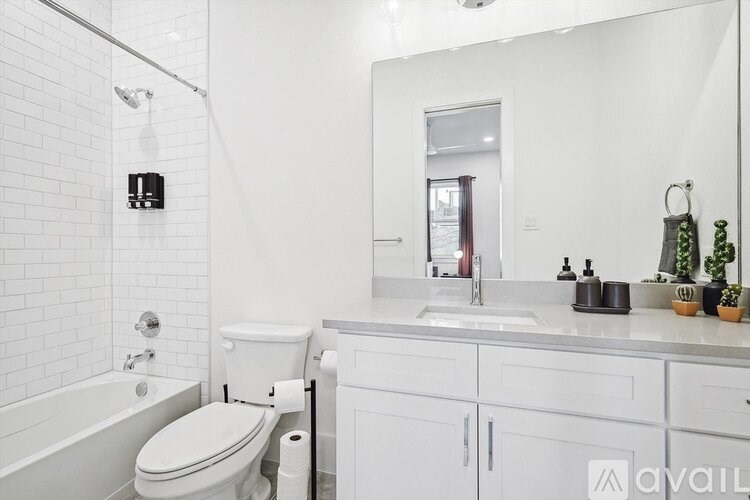 A white bathroom with a toilet, sink, and mirror.