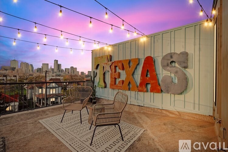 A balcony with a "TEXAS" sign and string lights.