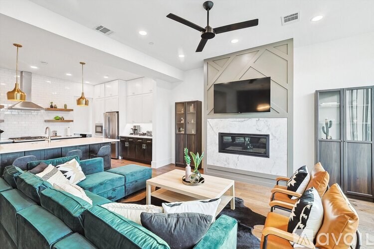 A modern living room with a green couch and a fireplace.