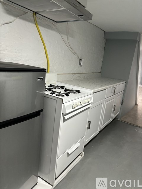 A kitchen with a stove and a refrigerator.