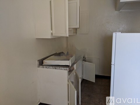 A kitchen with white cabinets and a white fridge.
