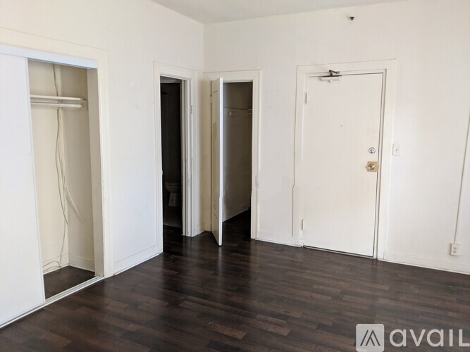 A room with a white door and a white wall with a window.