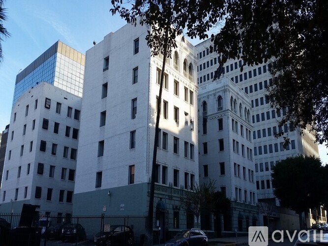 A white building with a blue glass window on the top floor.