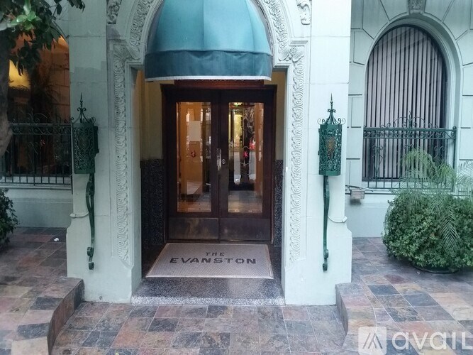The entrance to a building with a green awning and a sign that reads "The Evanston.".