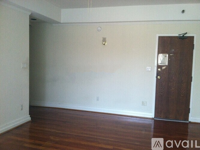 A room with a wooden floor and a brown door.
