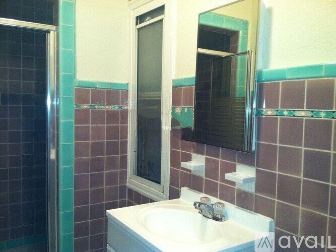 A bathroom with a white sink and a mirror.
