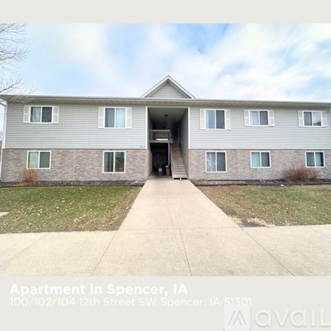 The image shows a two-story apartment building with a front entrance and a driveway.