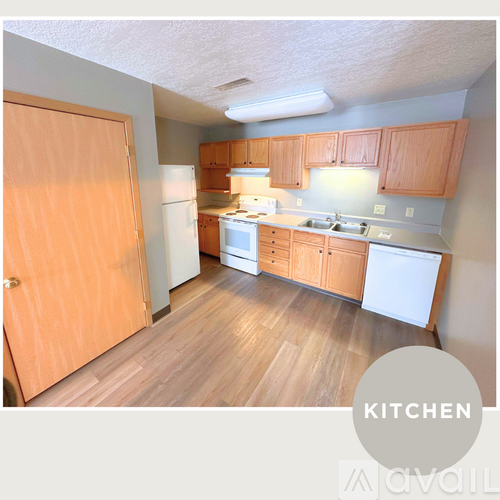 A kitchen with wooden floors and cabinets.