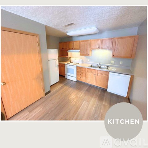 A kitchen with wooden floors and cabinets.