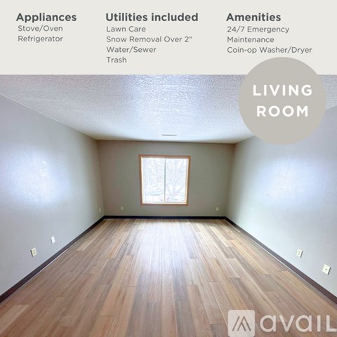 A living room with a window and wooden floor.