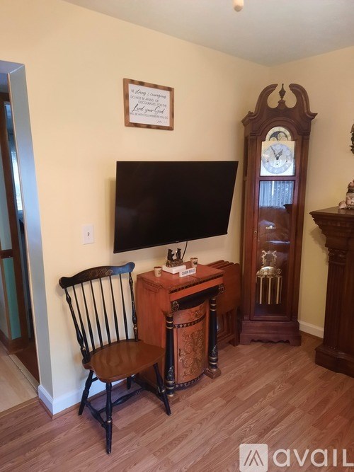 A wooden chair is in front of a desk with a computer monitor on it.