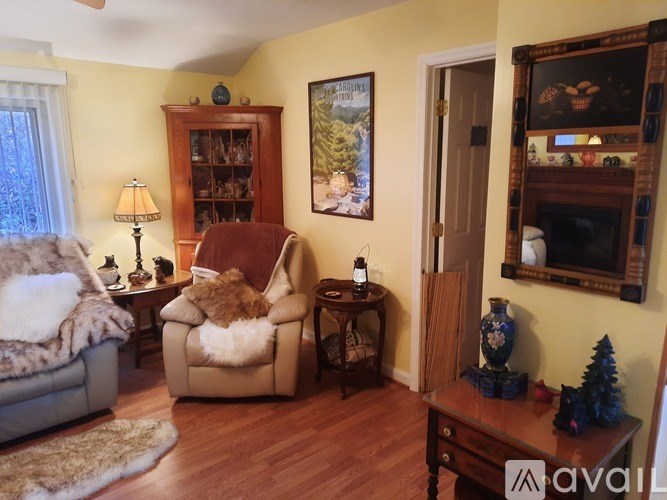 A living room with a brown chair and a painting on the wall.